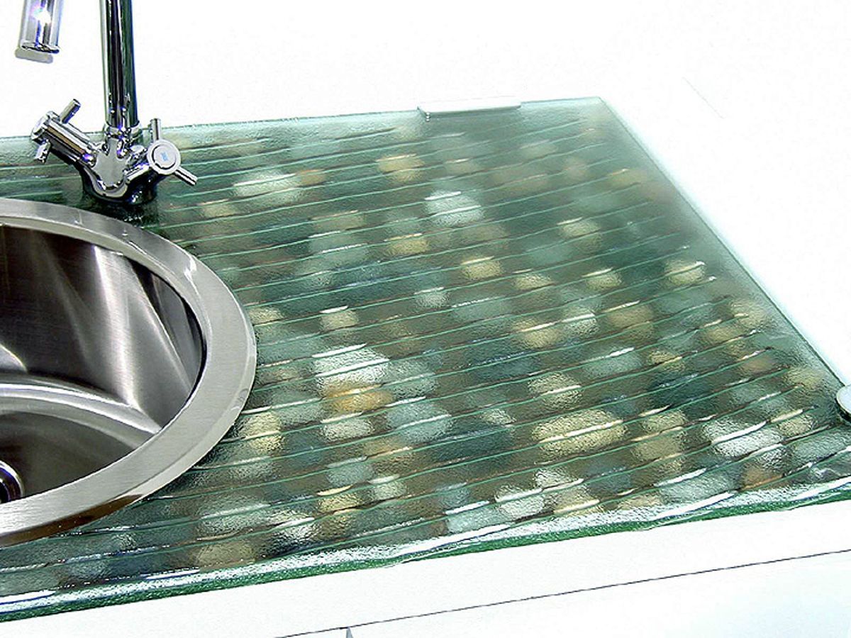 A glass sink with multicolored tile underneath. A glass sink with multicolored tile underneath.