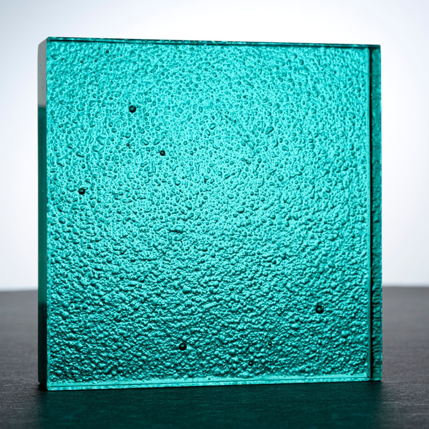 A square piece of green glass counter top
