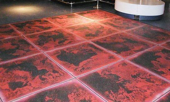 A red and black liquid lava tiled floor in a room.