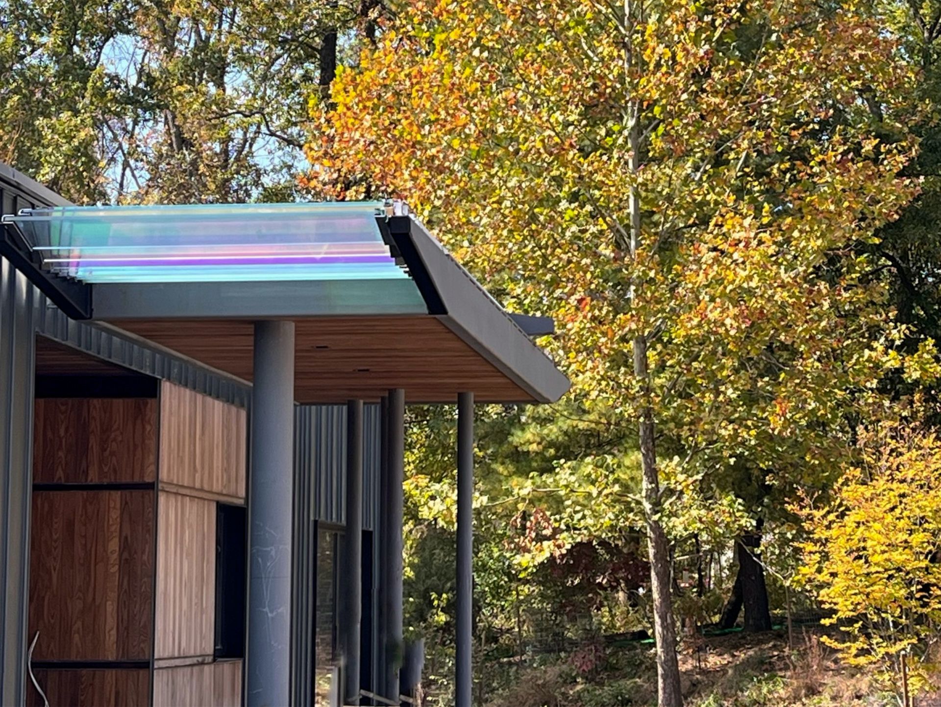 A house with a dichroic glass roof and trees in the background