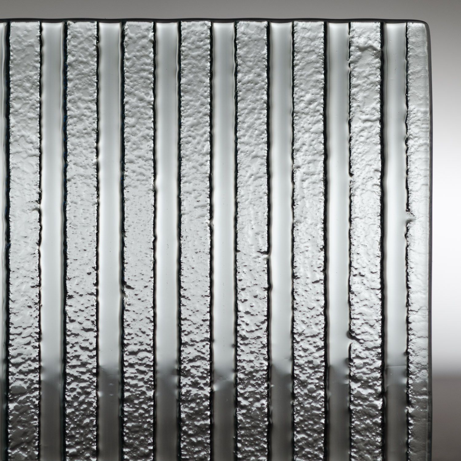 Vertical silver metal bars with a textured, frosted finish and dark edges