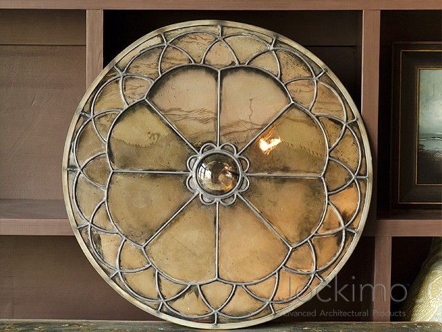 Decorative metal-and-beige round wall art with a floral lattice design on a wooden shelf unit.
