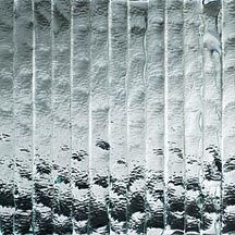 Silver corrugated metal wall with weathered white streaks and dark stains near the bottom
