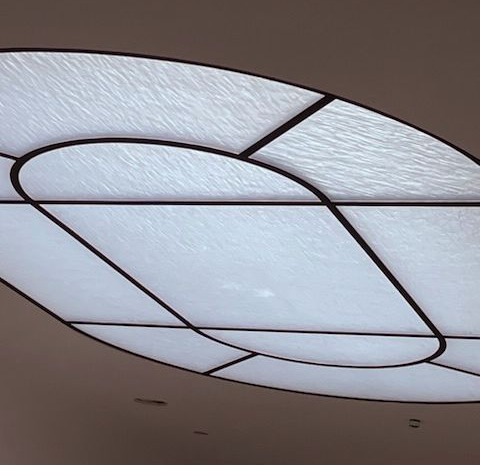 Geometric ceiling light fixture with a frosted glass-like surface and black metal frames.