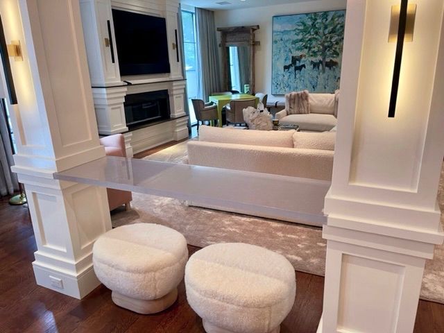 A living room with a couch , ottomans and a television.