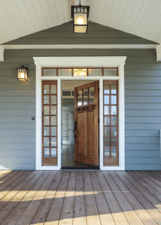 The front door of a house with a wooden deck