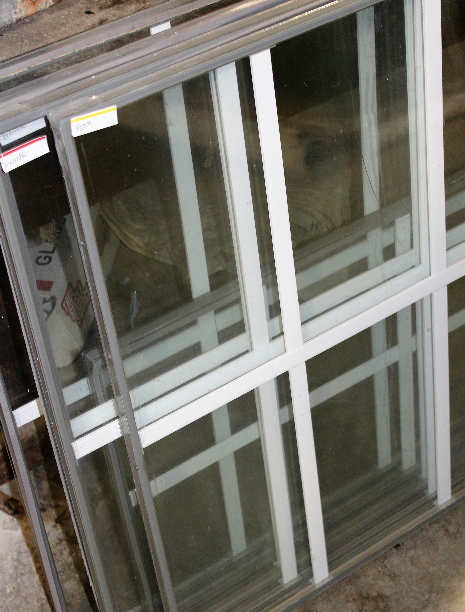Stack of rectangular glass windows with white and gray frames.