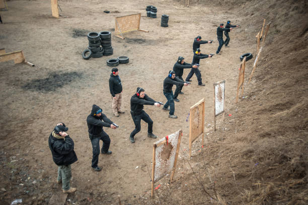 Students group with instructors practice gun shooting
