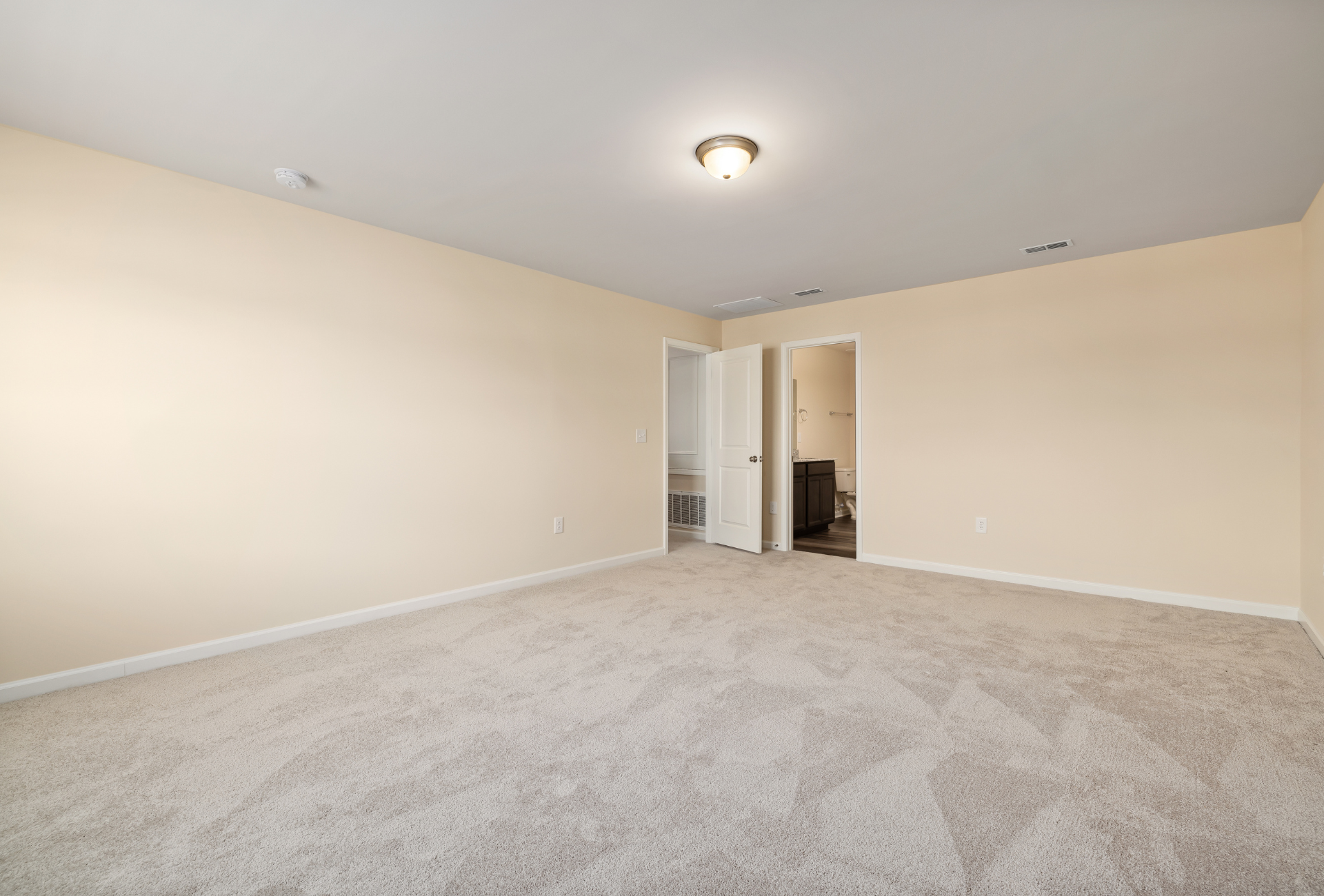An empty living room with hardwood floors and a ceiling fan.