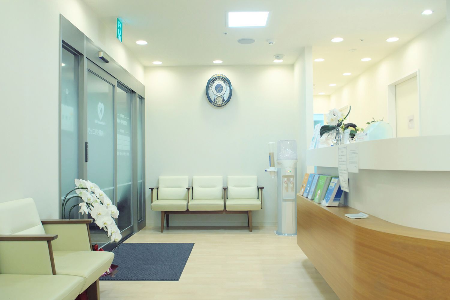Brightly lit doctor's office waiting room with chairs, reception desk, and glass doors. Brightly lit doctor's office waiting room with chairs, reception desk, and glass doors.