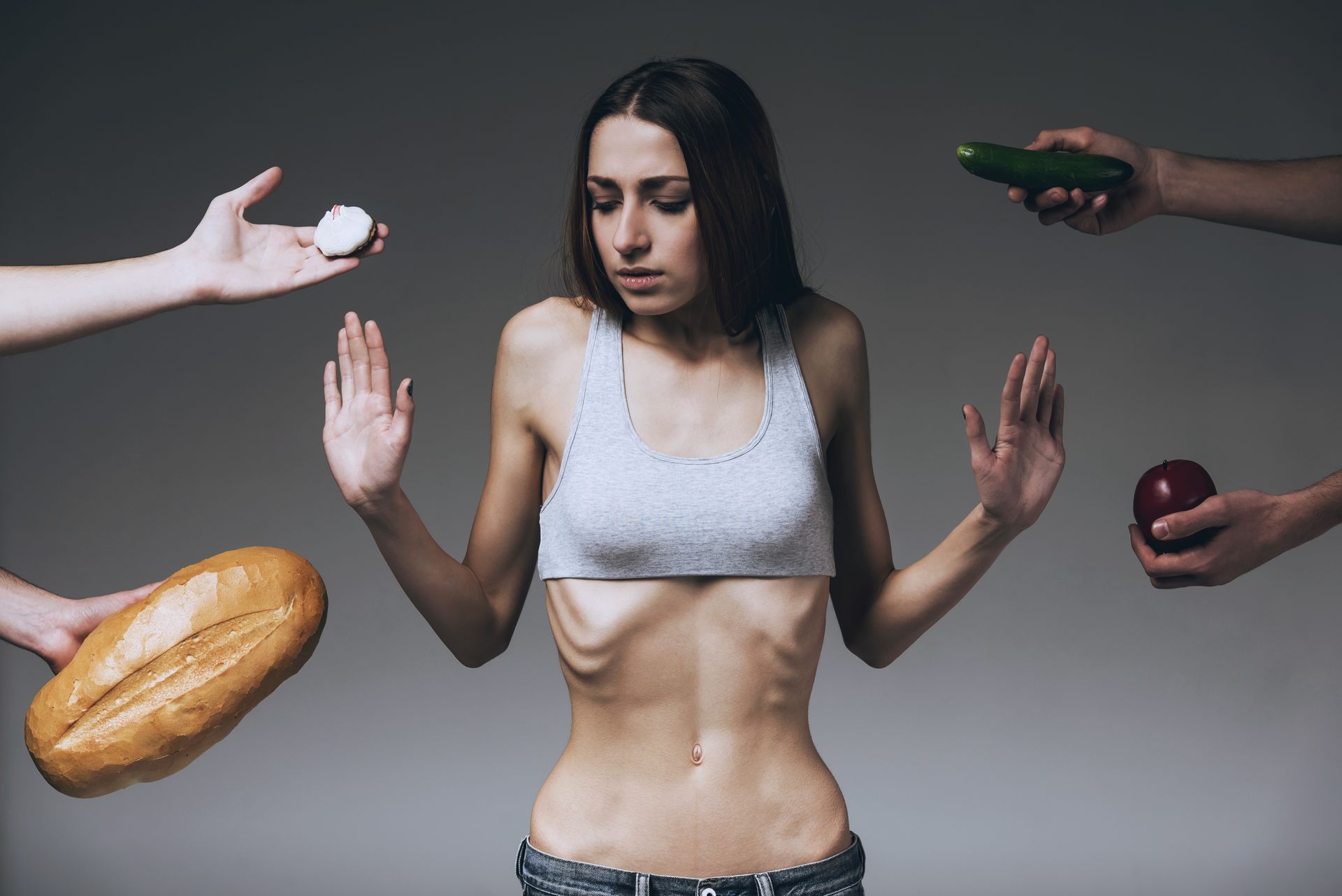 Underweight person with hands outstretched, rejecting food: bread, pills, cucumber, and apple. Underweight person with hands outstretched, rejecting food: bread, pills, cucumber, and apple.