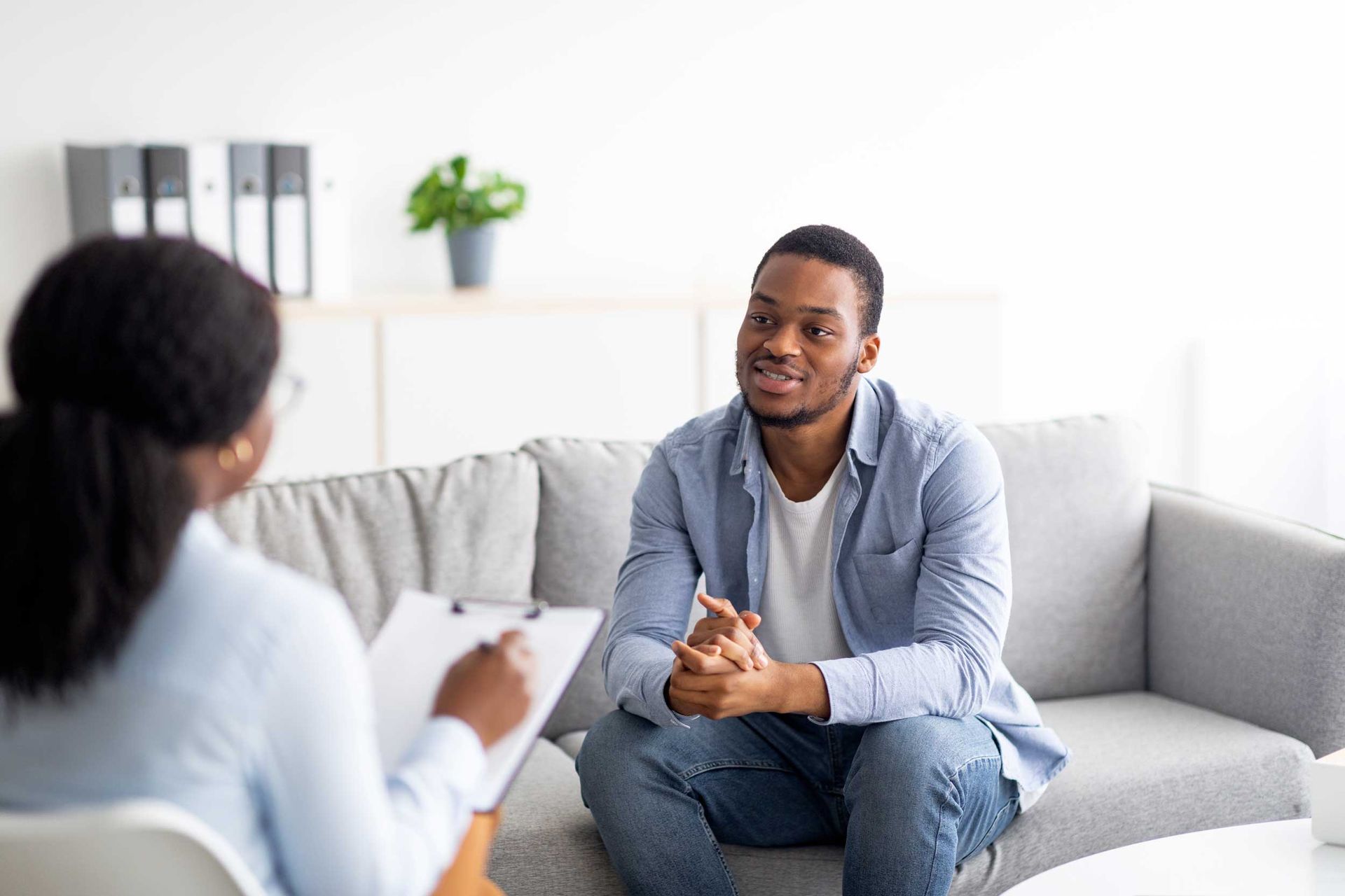 Two people are seated in an office during a mental health therapy session Two people are seated in an office during a mental health therapy session