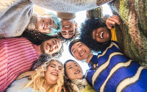 Group of diverse people smiling and looking down, forming a circle. Group of diverse people smiling and looking down, forming a circle.