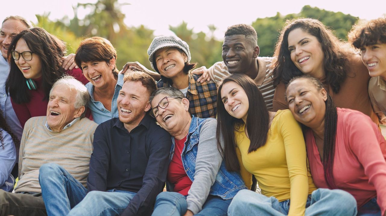Group of diverse people smiling and laughing outdoors in the sunlight. Group of diverse people smiling and laughing outdoors in the sunlight.