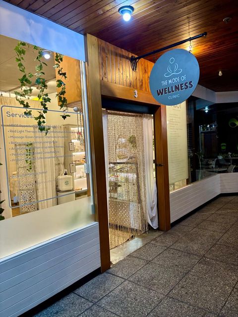 Shopfront with a sign for "Natura Wellness" above the door. A bead curtain hangs in the doorway.