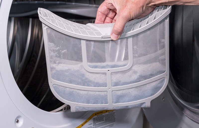 hand holding the dryer lint trap full of lint, needs cleaning
