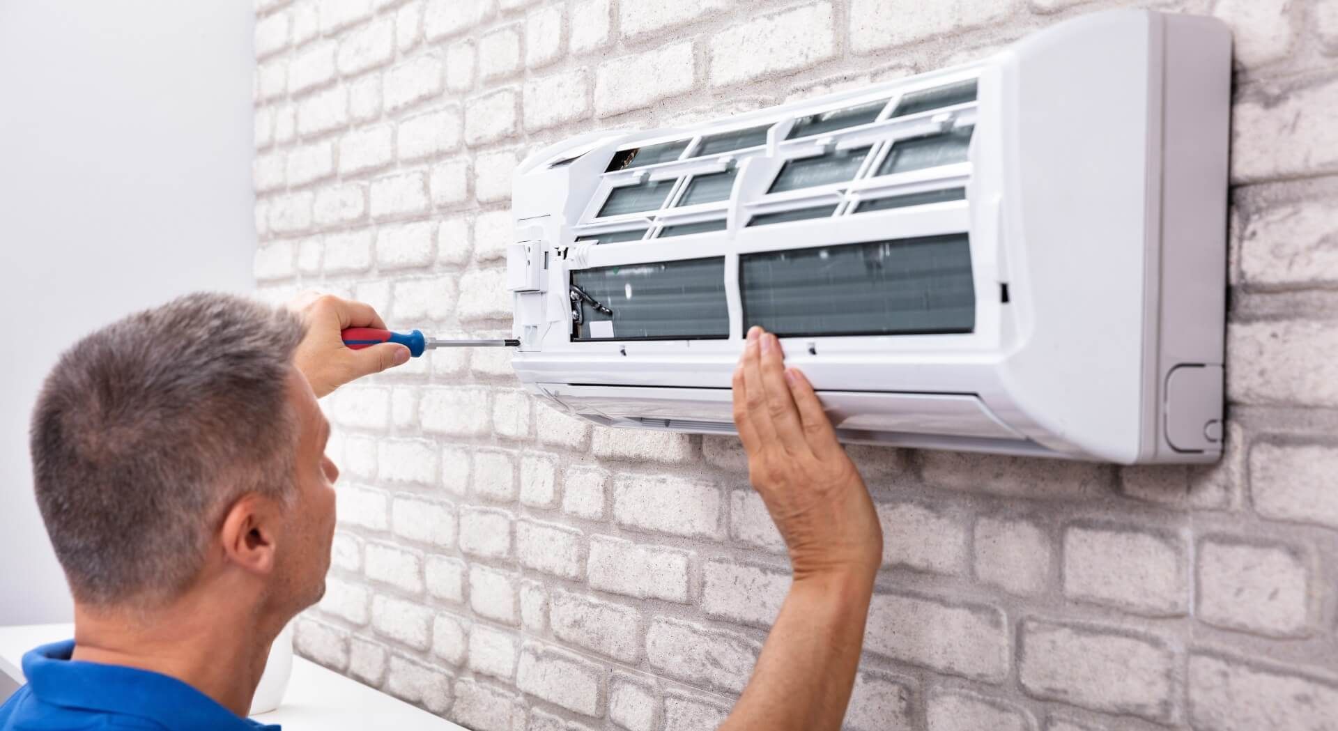 Man fixing the air conditioner in the house