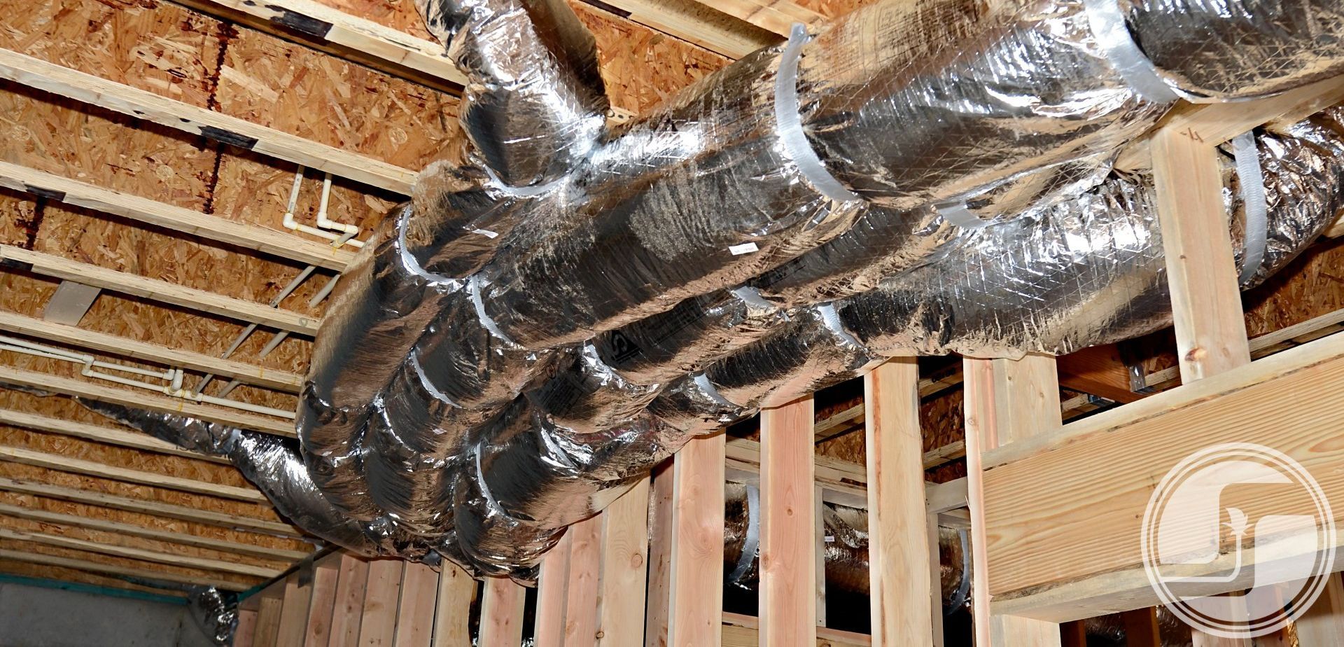 Several ducts hanging from the ceiling of an unfinished basement.