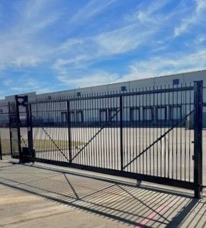 A sliding gate is sitting in front of a building.