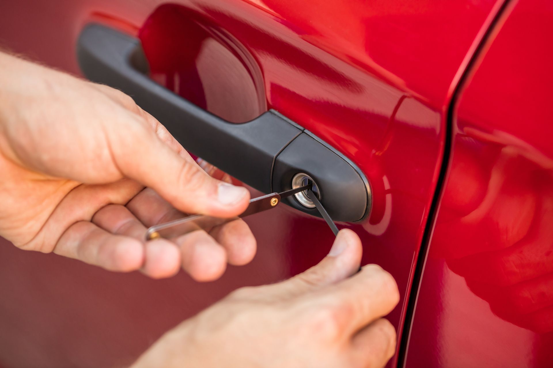 A person is opening a car door with a key.
