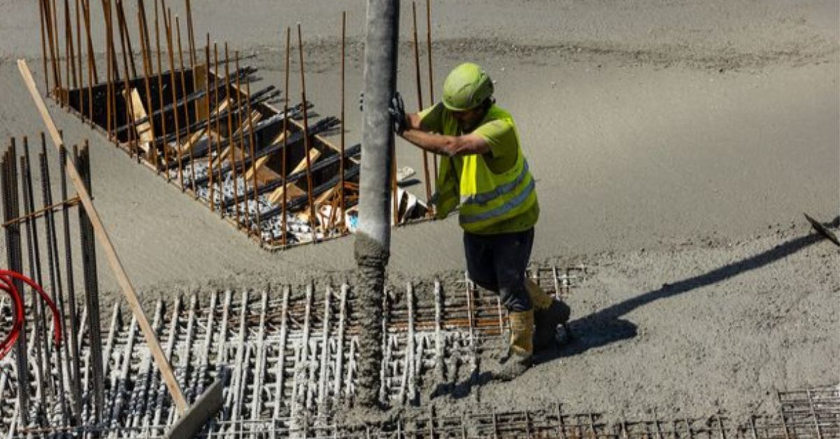 Worker pouring concrete foundation at a construction site by ABI Corporation