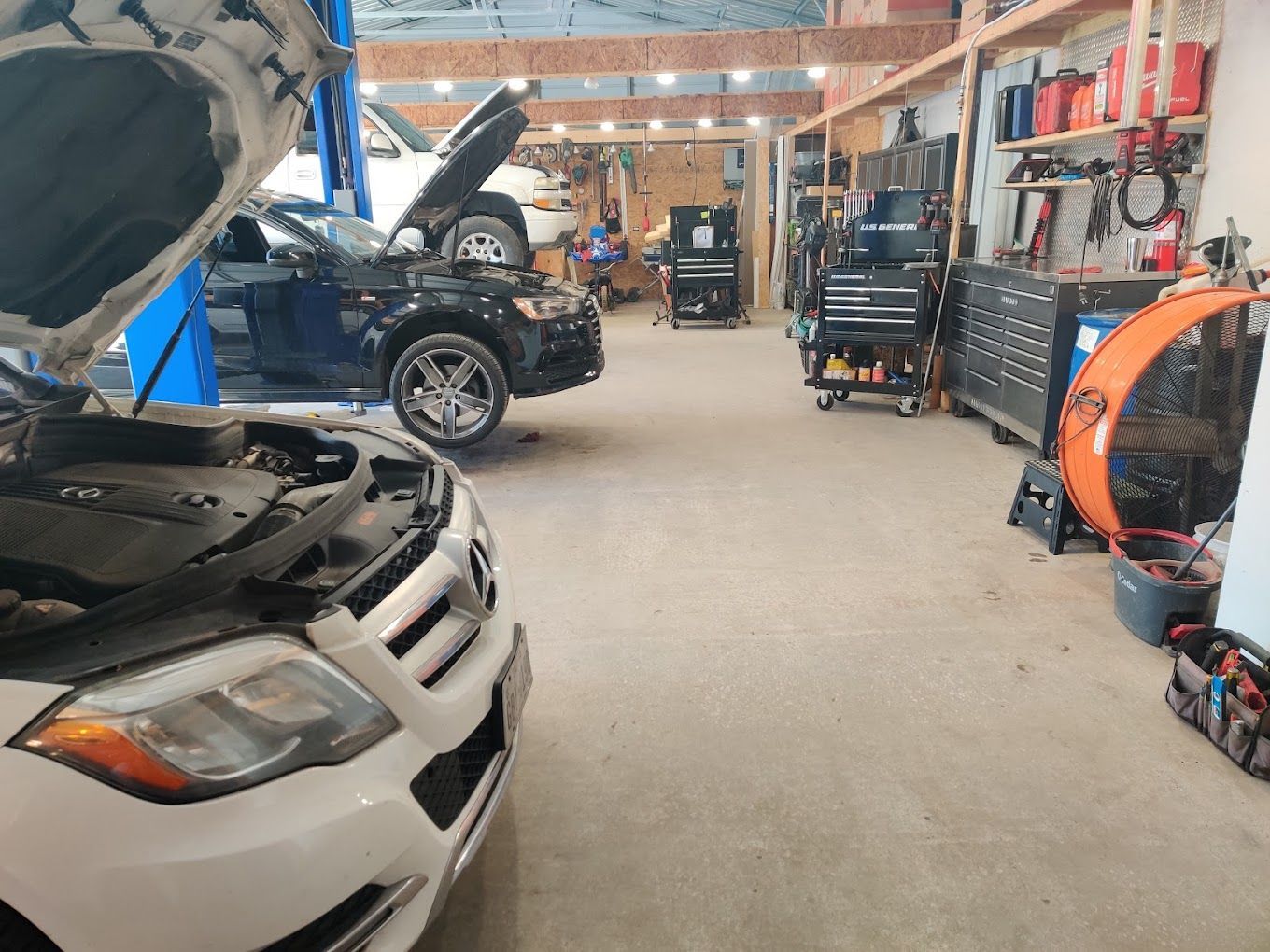 Auto repair shop interior with cars on lifts, tools, and workbenches. | Freedom Auto Repair