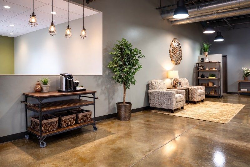 Modern lobby for Direct Cremation Moore, OK with seating area, coffee station, plants, and warm pendant lighting