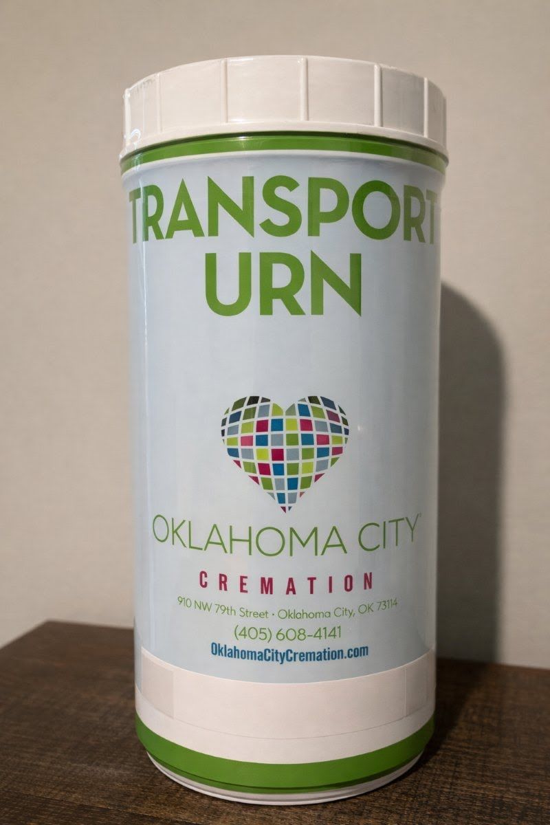 Transport urn container for Direct Cremation Moore, OK with labeled design and secure lid on indoor surface
