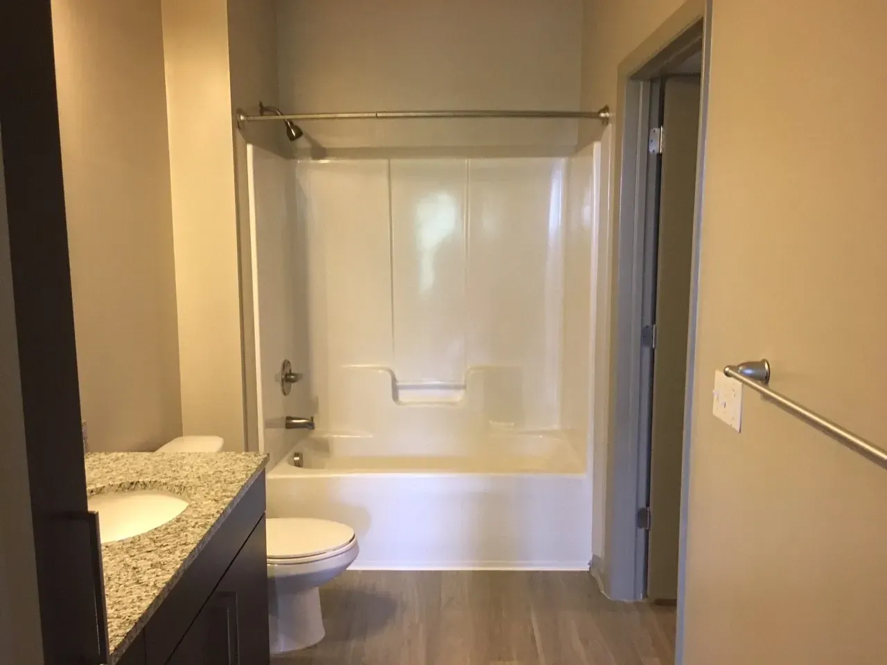 Bathroom with toilet, vanity, and bathtub/shower combo.
