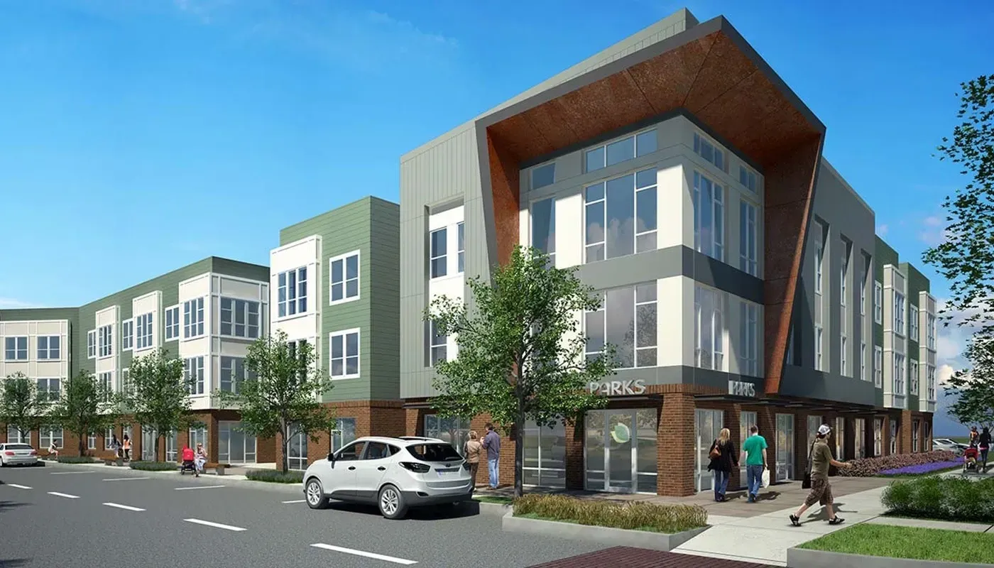 Modern apartment building exterior with green and gray paneling and large windows.