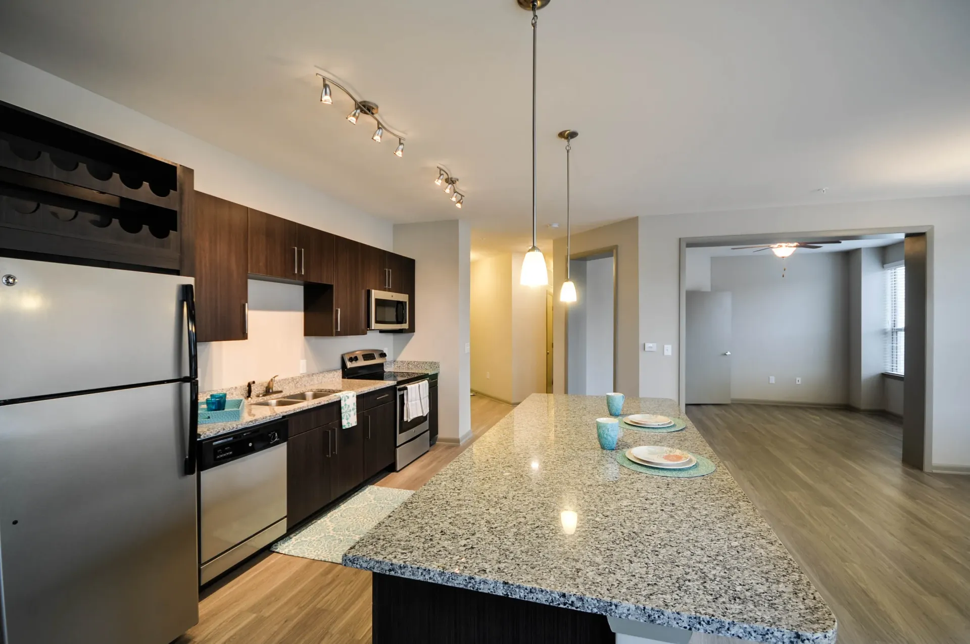 Modern kitchen with granite island and stainless steel appliances.
