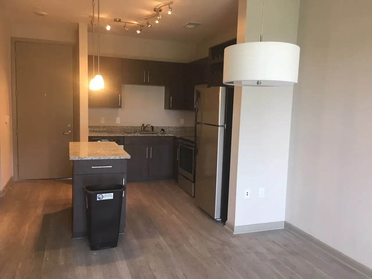 Modern kitchen with island and stainless steel appliances.