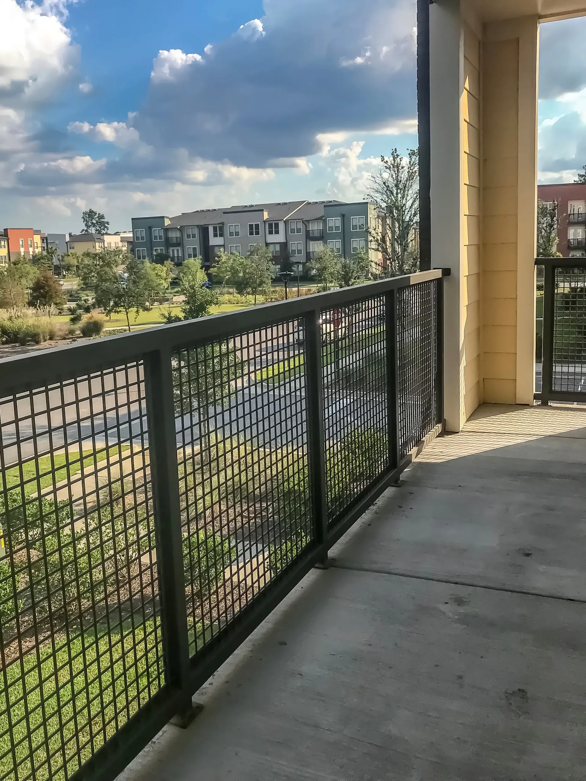 Balcony view of apartment buildings and green spaces.