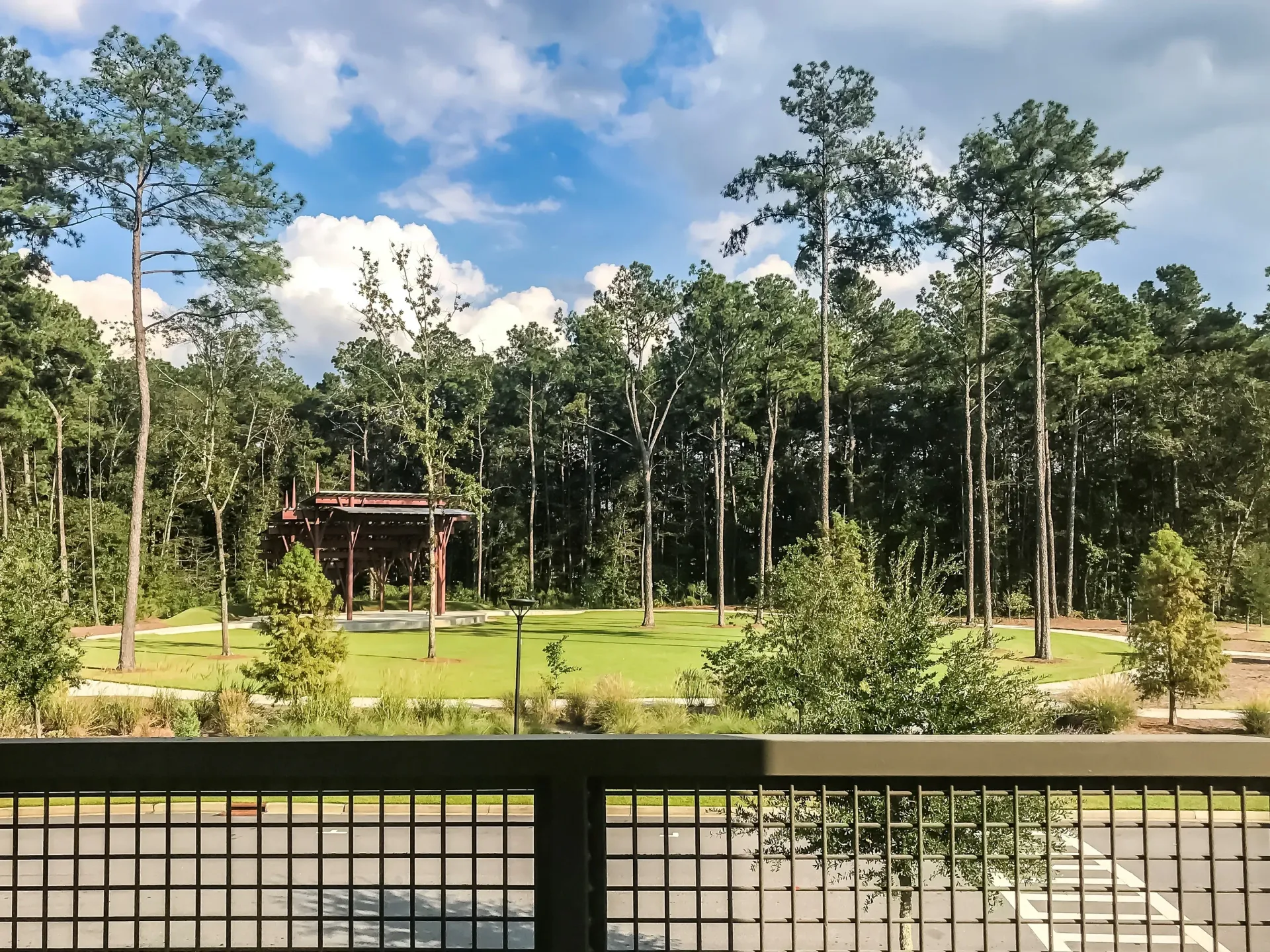 Community park with a covered pavilion and walking paths surrounded by trees.