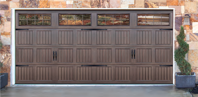 Brown paneled garage door with windows set in a stone exterior