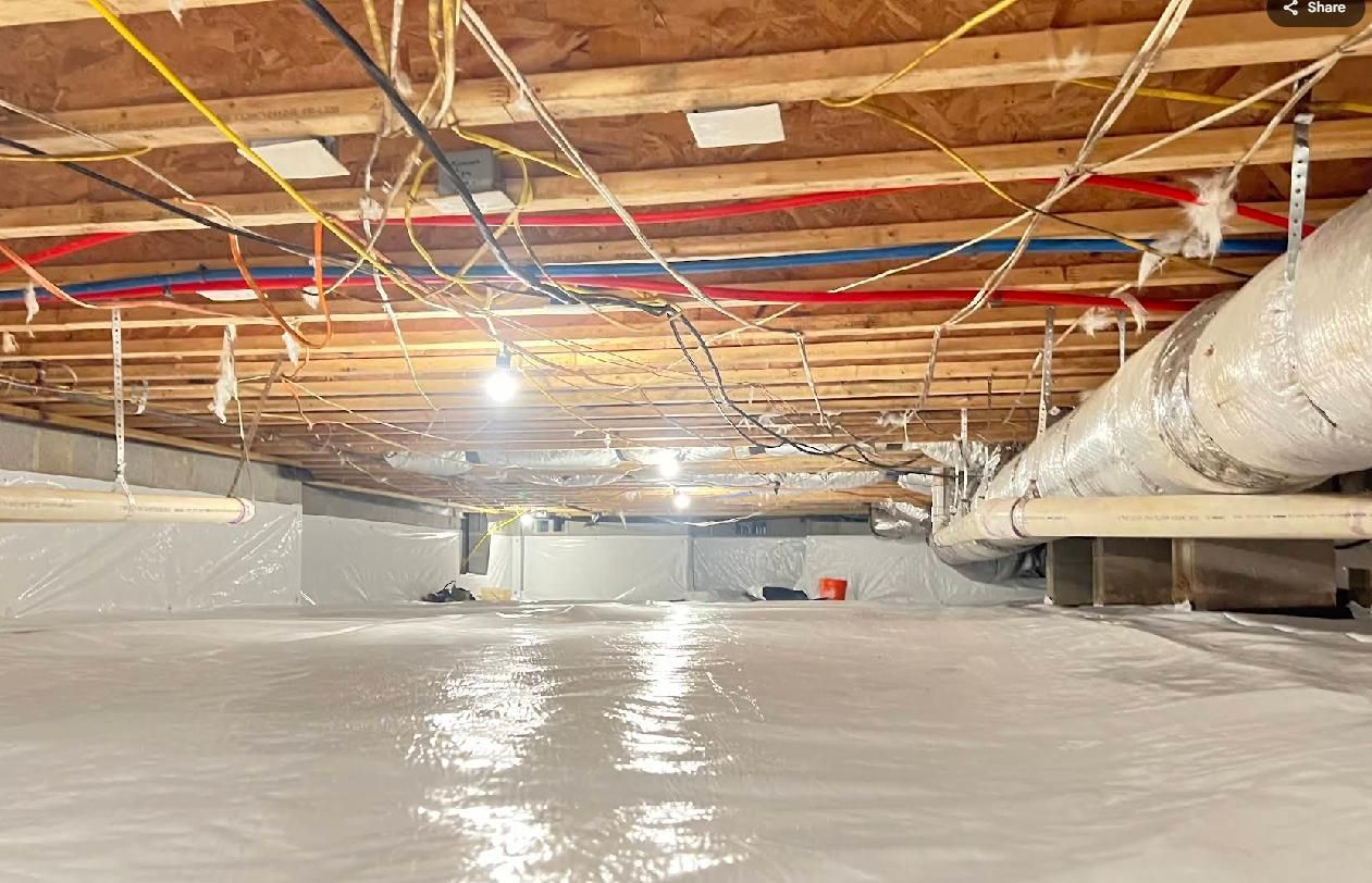 Crawlspace with exposed framing, wiring, and ductwork. Floor covered with a reflective, light-colored material.