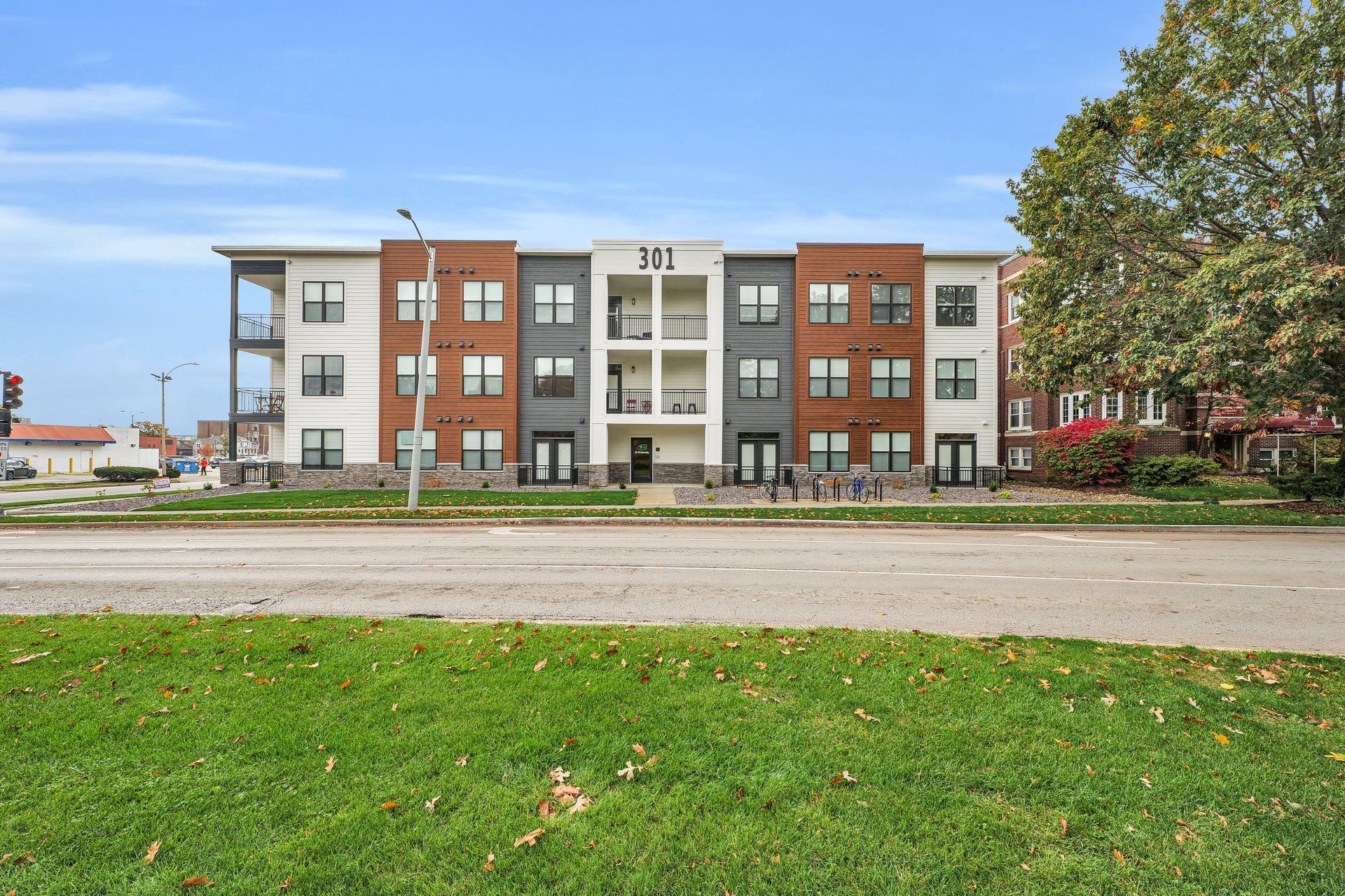 Photo showing a 3 story building with balconies, seen from across the streeet