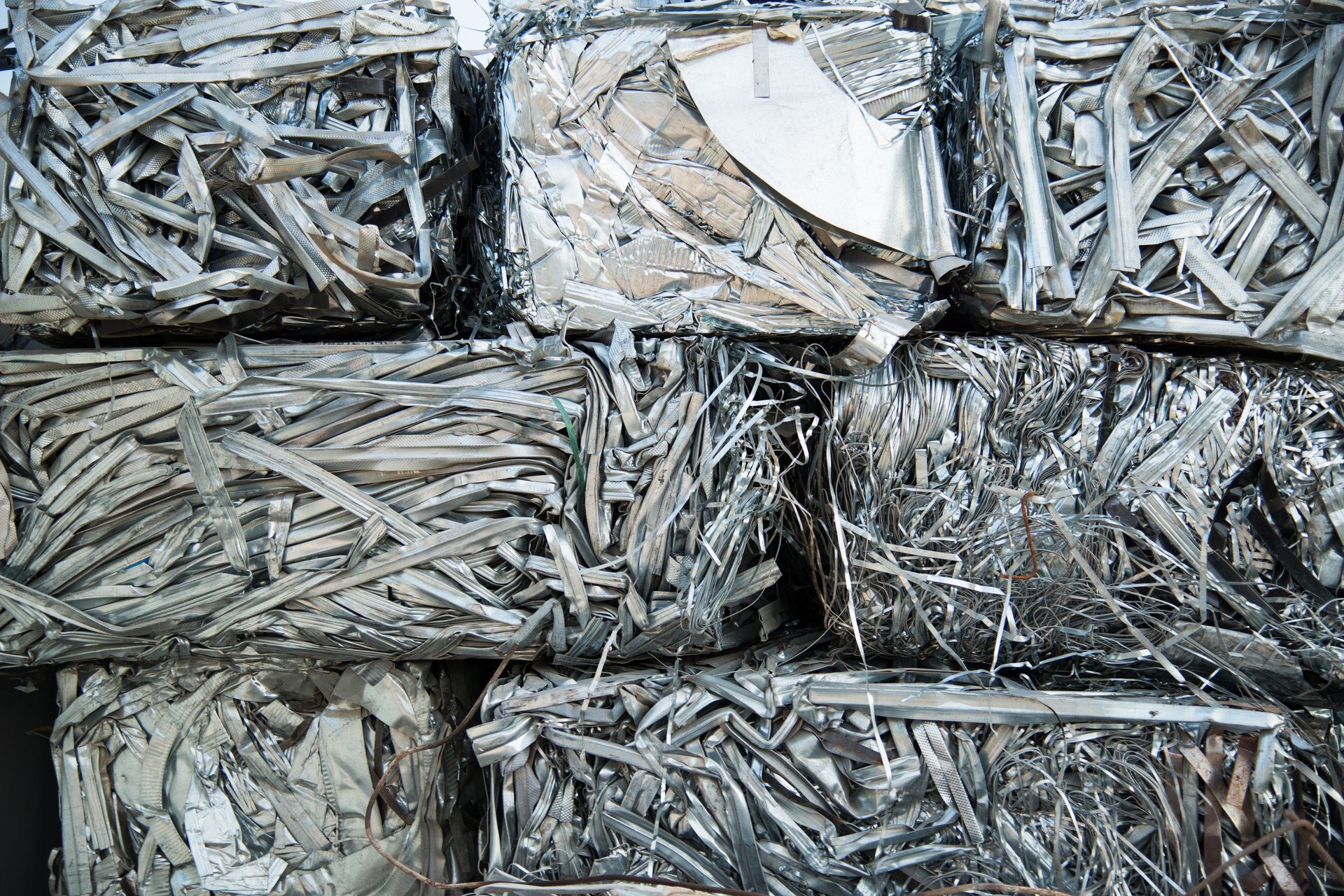 Large pile of scrap metal pieces stacked at an industrial recycling site. Large pile of scrap metal pieces stacked at an industrial recycling site.