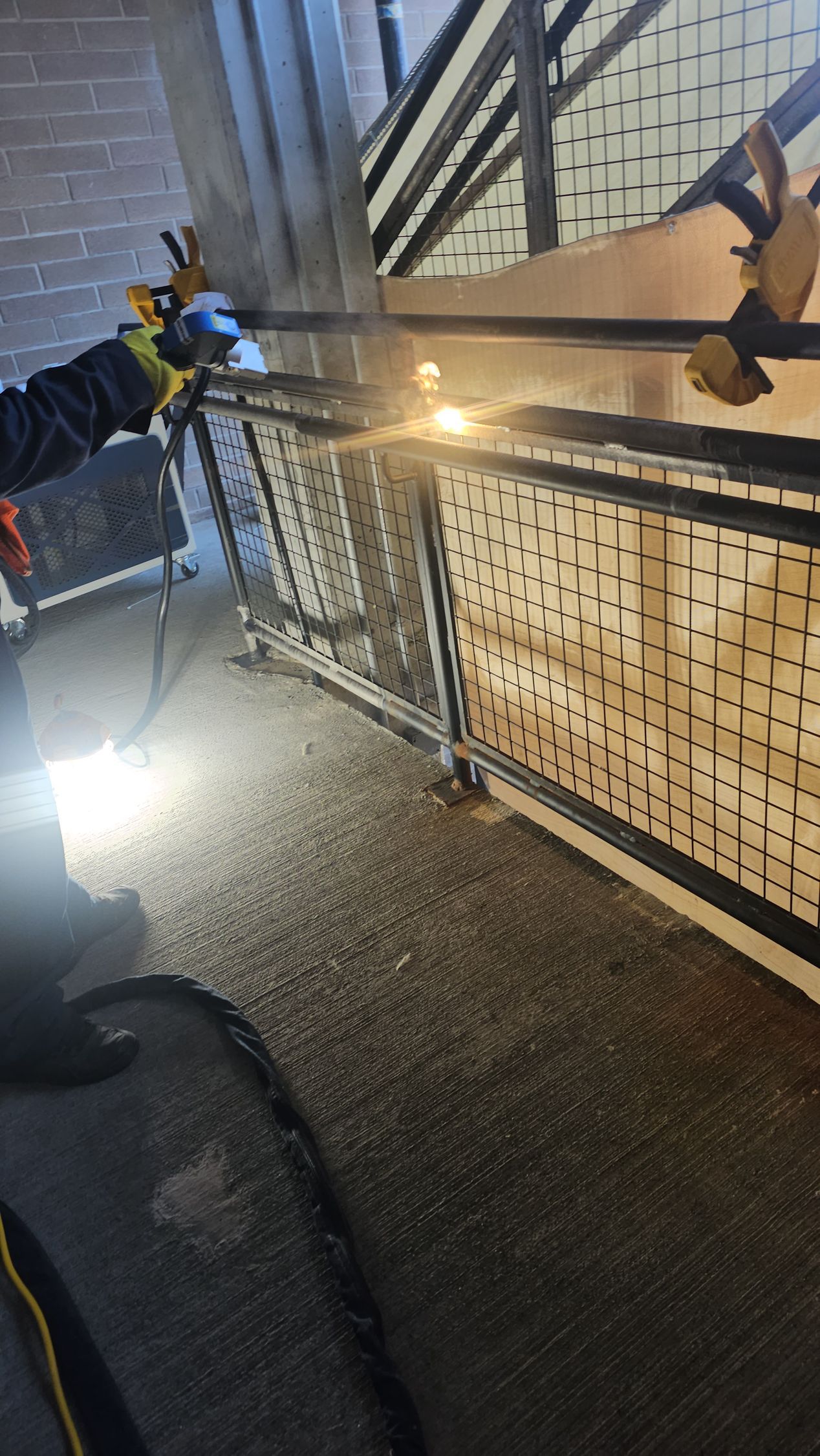 Welder using a torch on a metal frame, sparks flying, indoors.