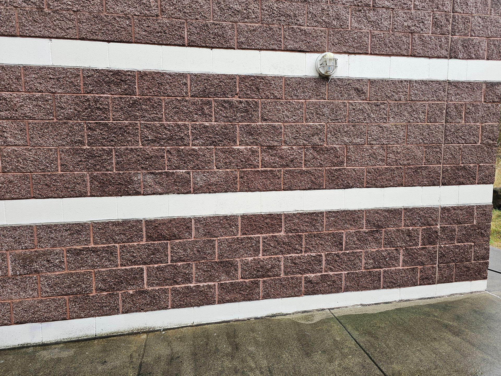 Brick wall with white horizontal bands.