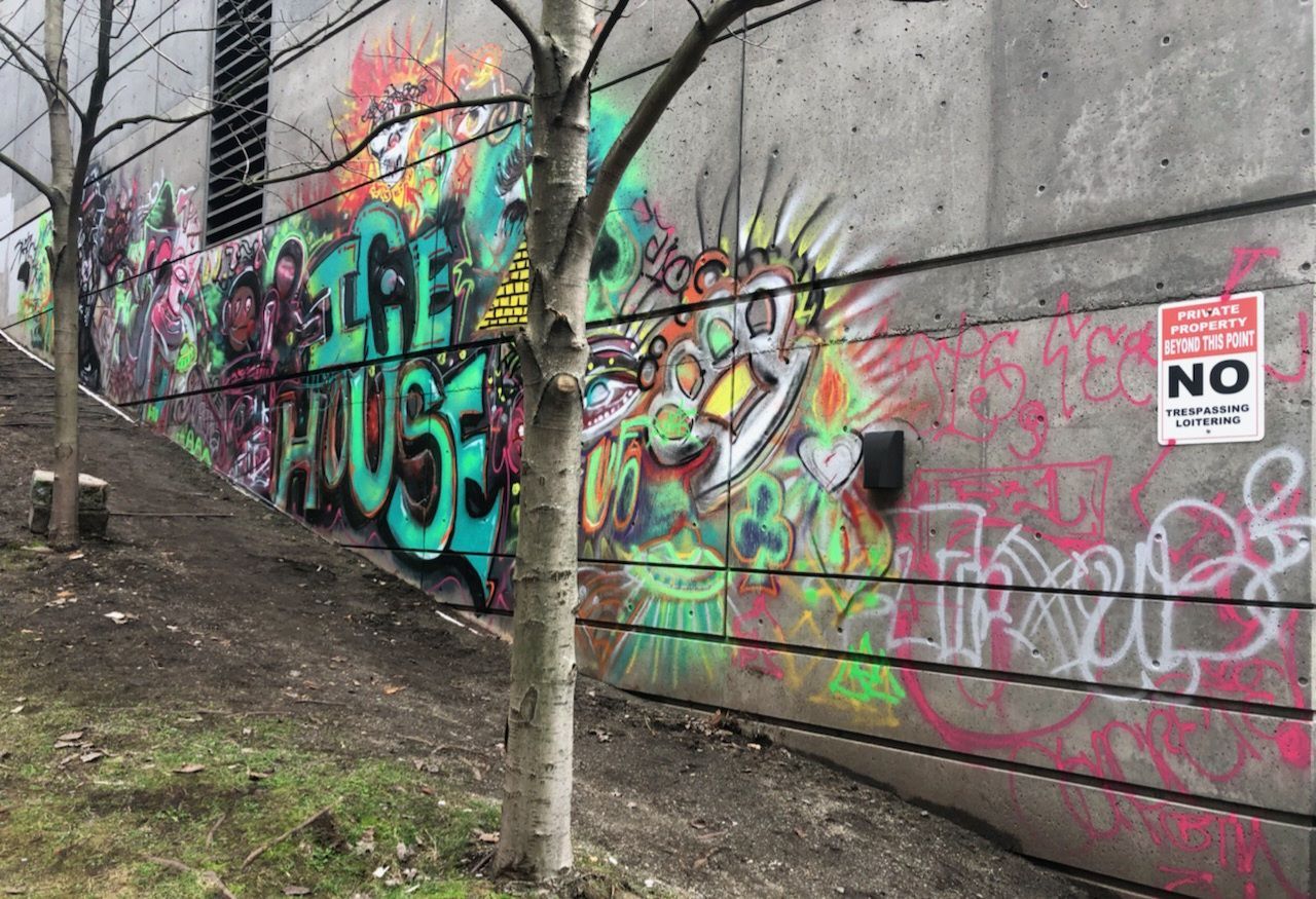 Graffiti art on a concrete wall, including a bird-like figure and text 