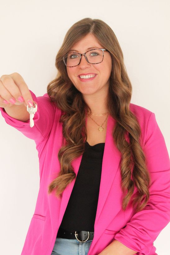 A woman holding up a key.