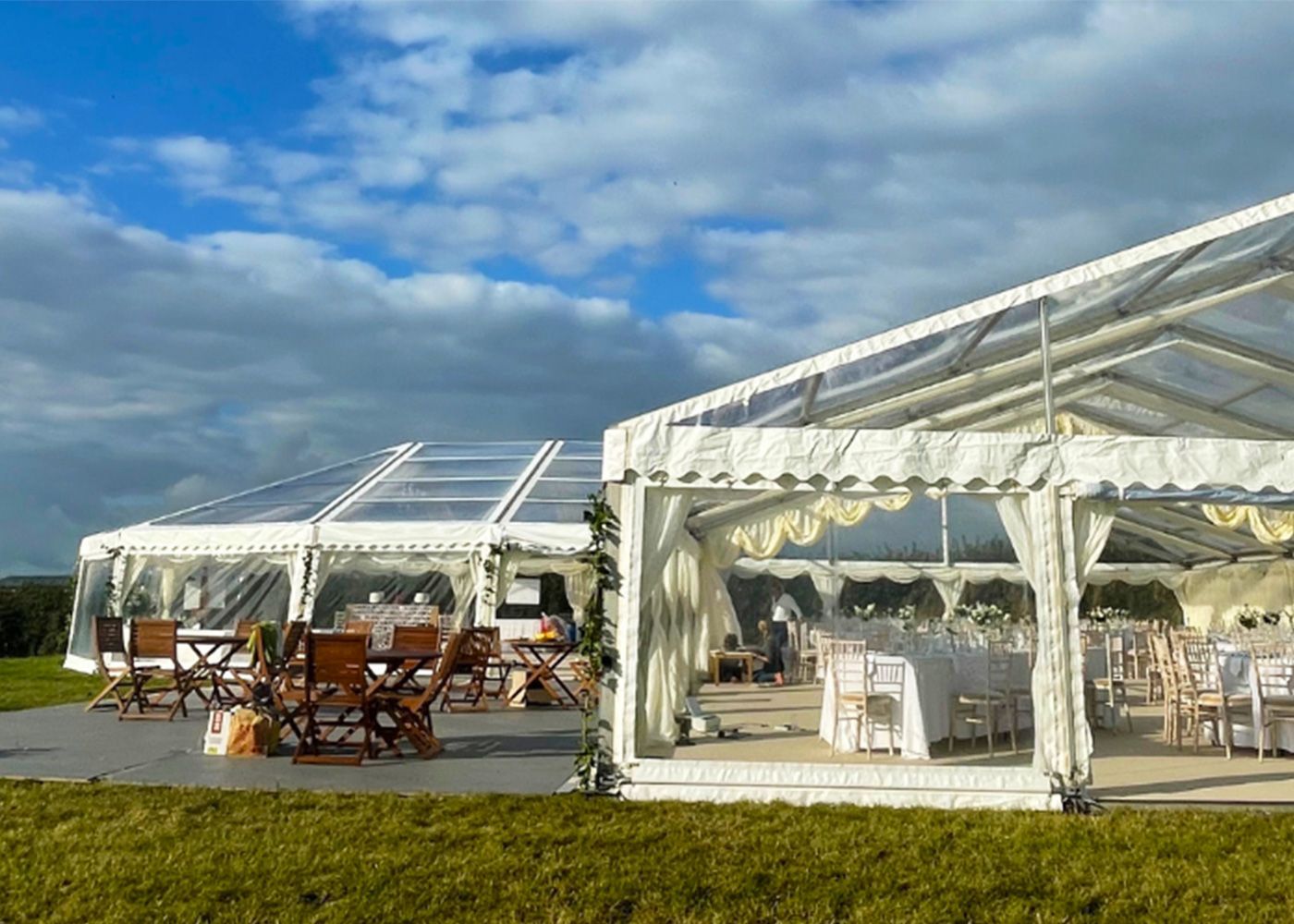 Two clear tents are sitting in the middle of a grassy field.