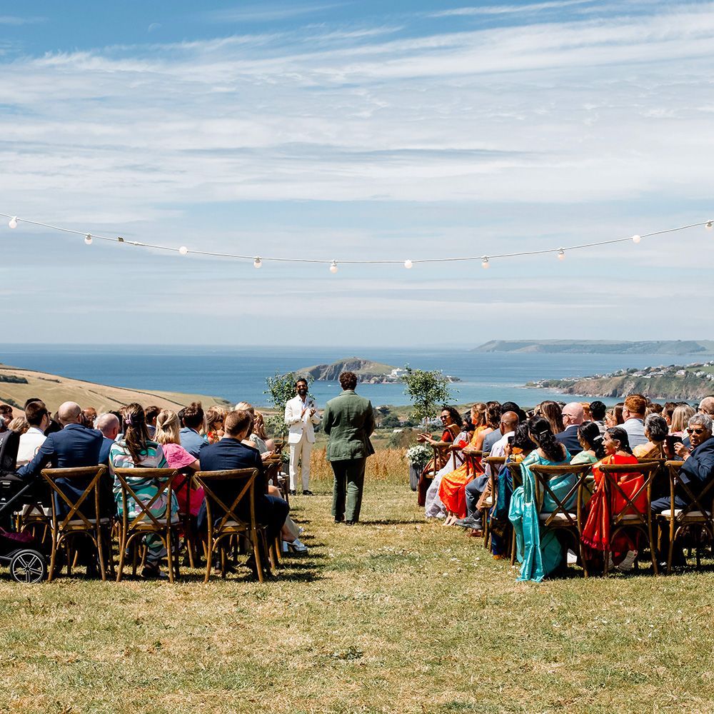 A large group of people are sitting in chairs at a wedding ceremony.