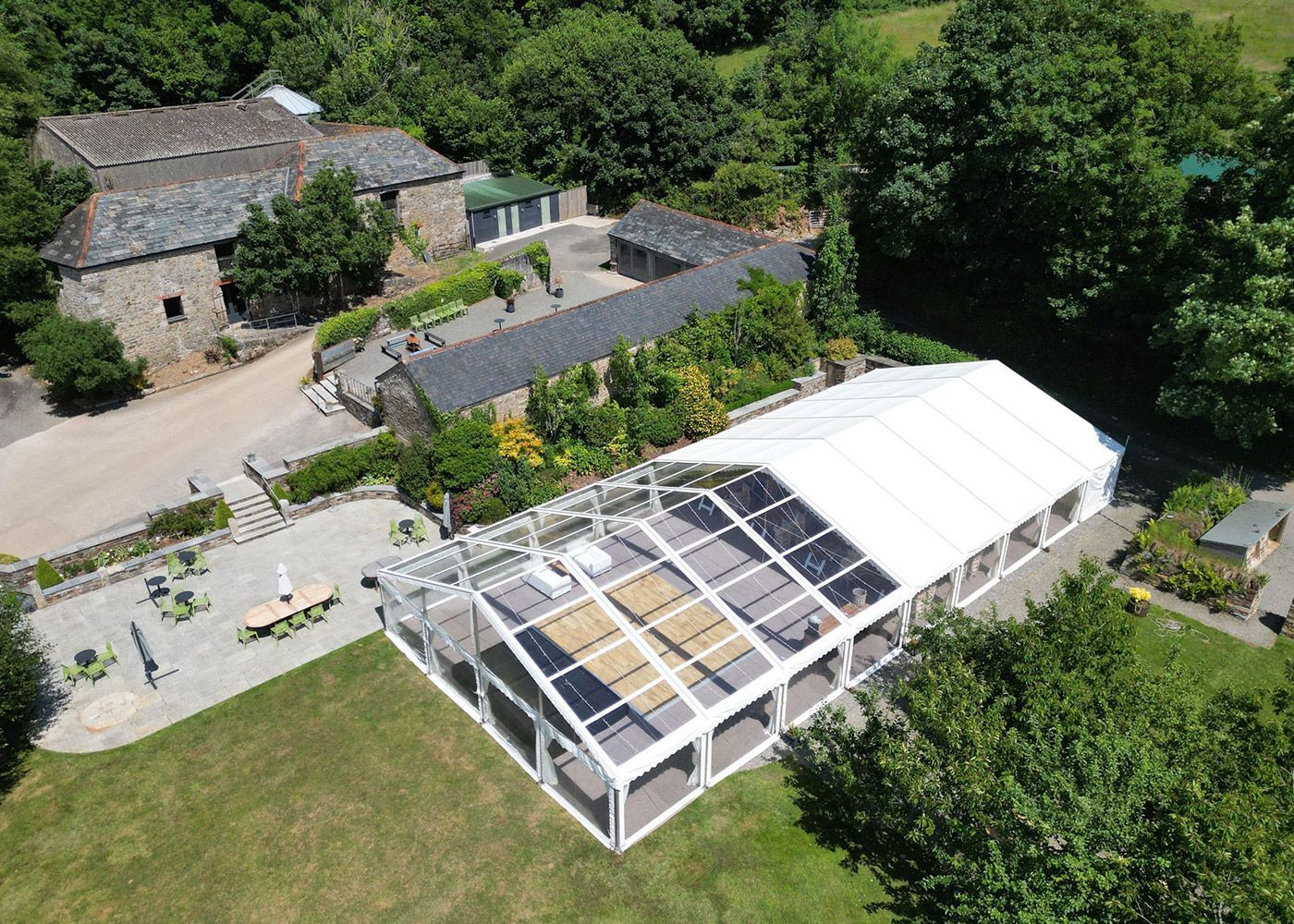 An aerial view of a large clear tent in a field.