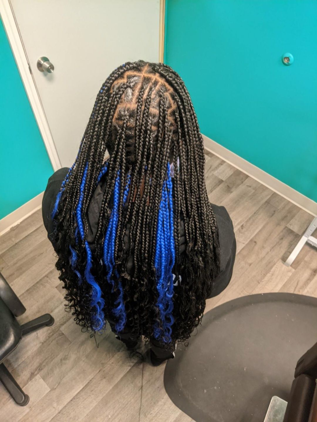 Black braids with blue curly extensions.