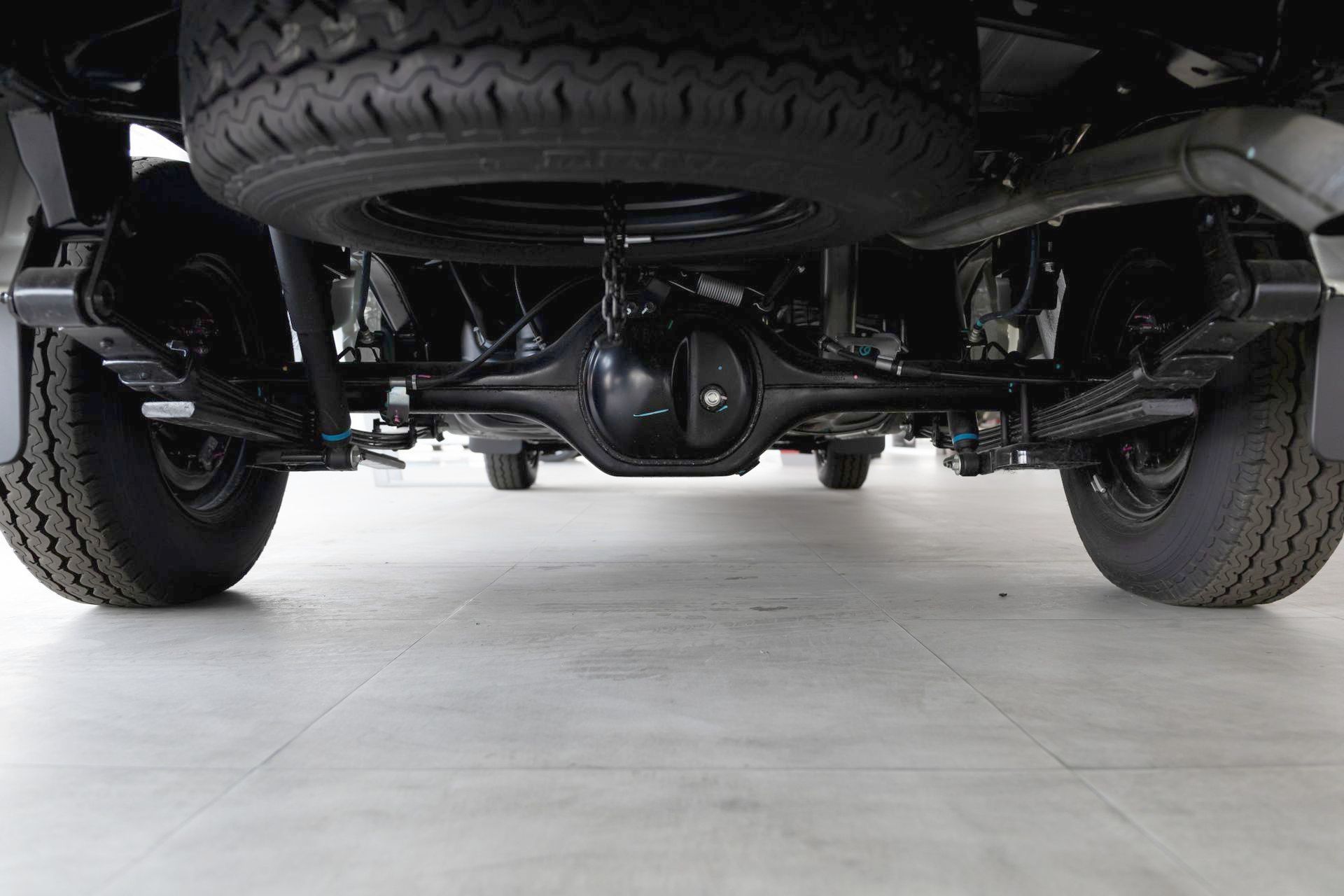 A close up of the underside of a car in a parking lot.