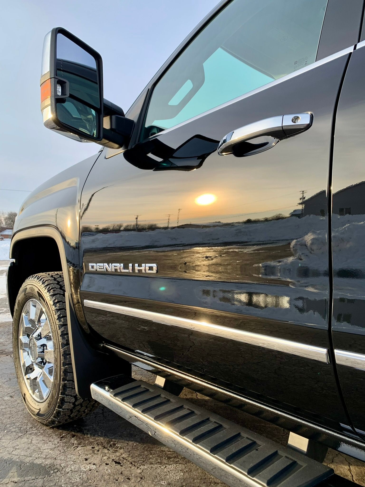 A black truck is parked on the side of the road.