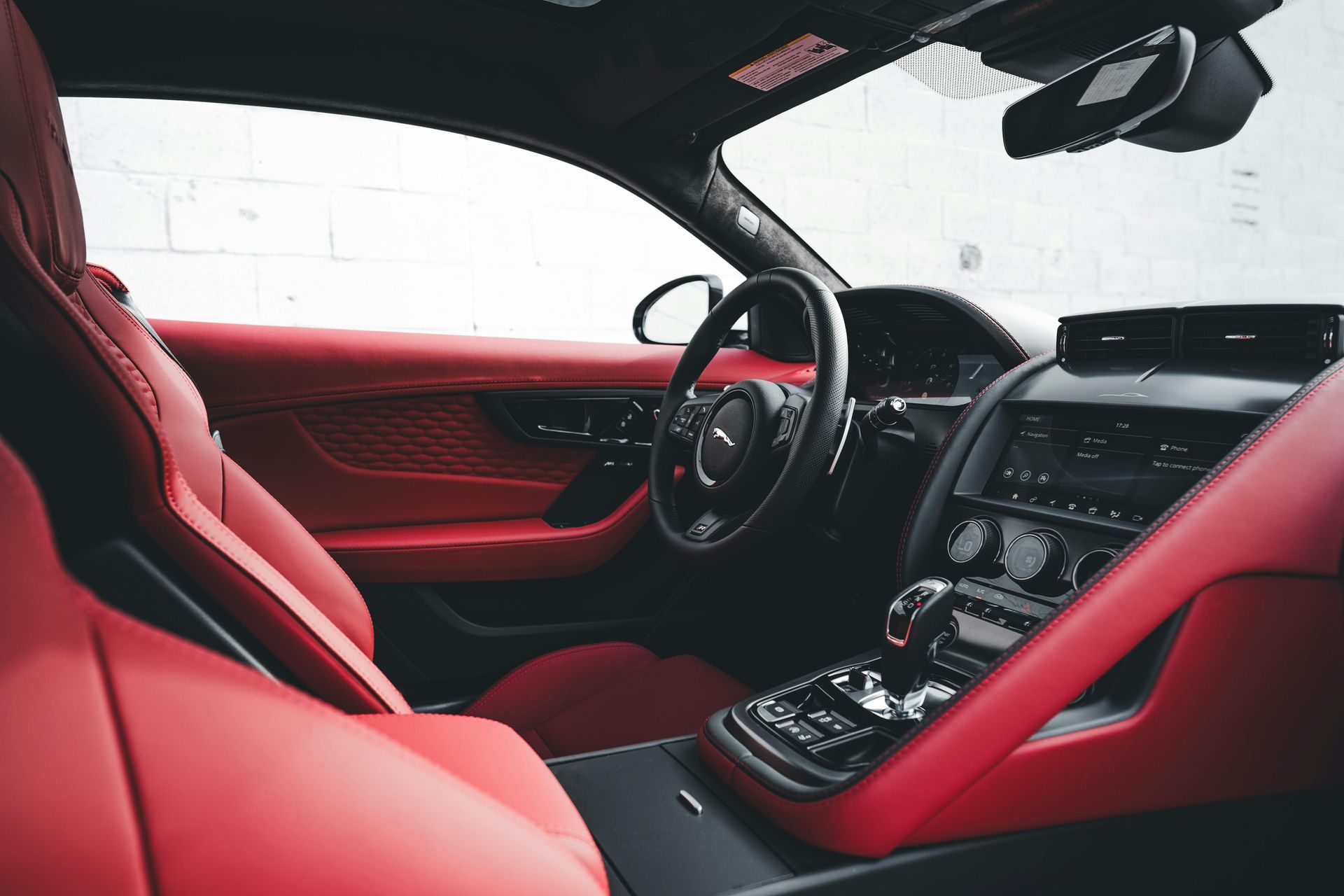 The interior of a car with red seats and a steering wheel.