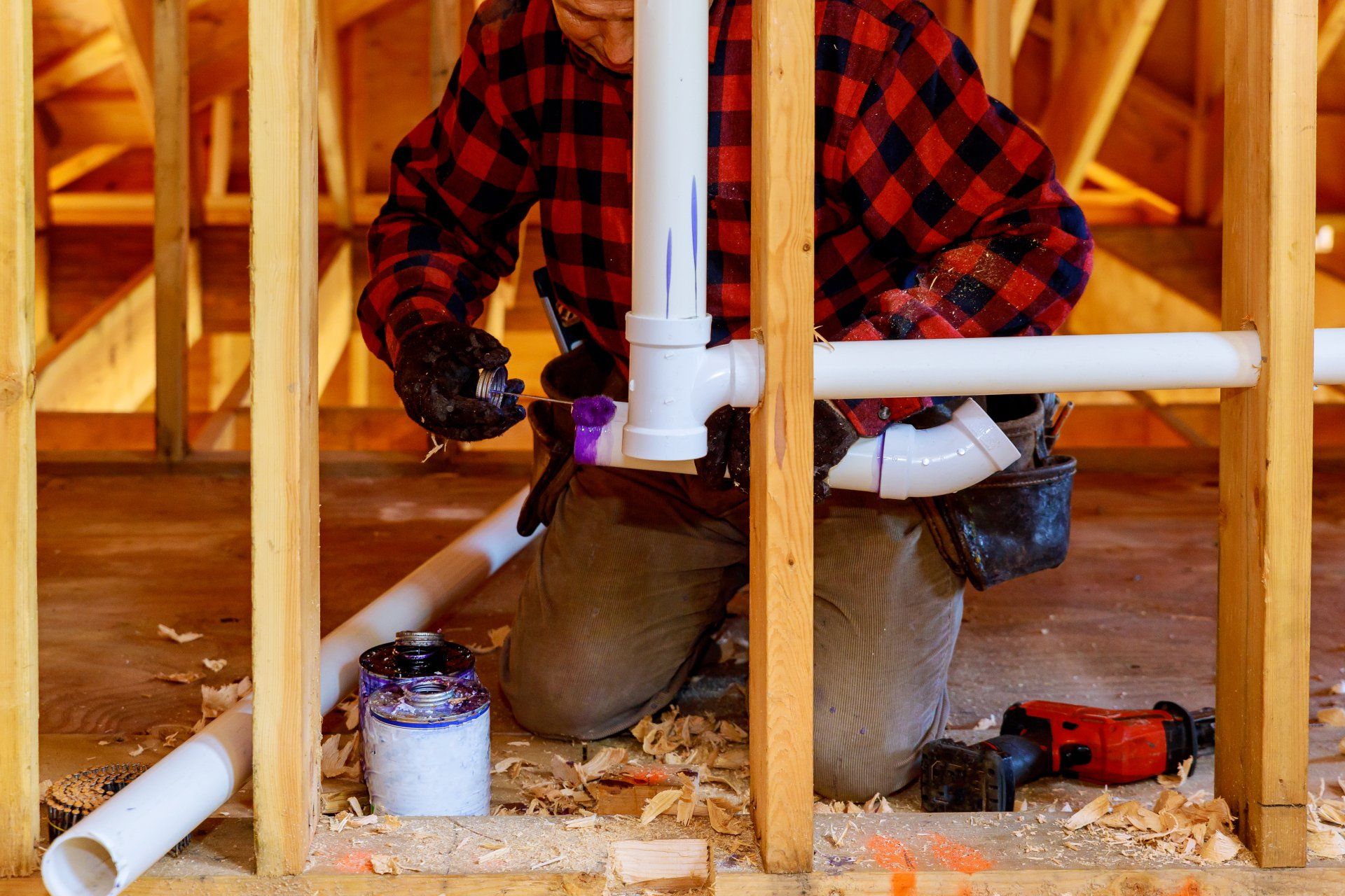 Applying plumber pipe drain and vent plumbing system at new home construction